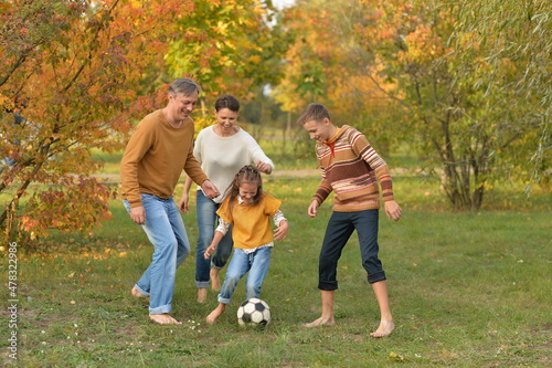 Portrait of big happy family playing football in park