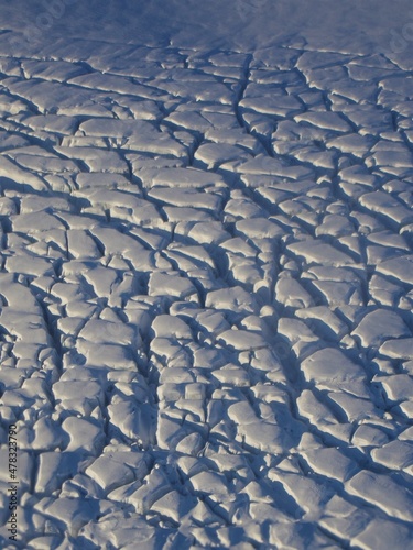 Crevasses on the surface of M  rdalsj  kull  Myrdalsjokull  glacier in Iceland. The cracks on the ice surface are white and blue  with the sun shining. Beautiful ice texture and natural pattern.