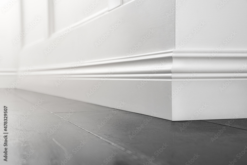 Close up of decorative, moulding white baseboard corner in empty room with copy space - obrazy, fototapety, plakaty 