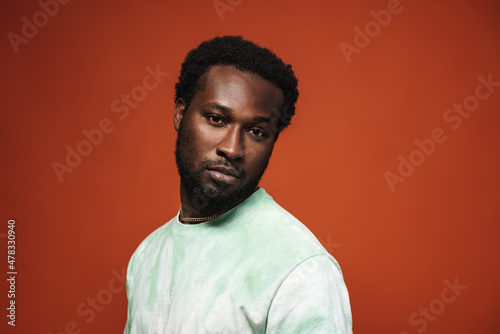 Young black man with beard posing and looking aside