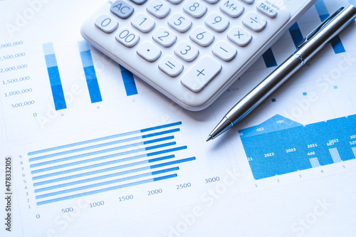 Calculator, steel pen, and financial data with graphs. The calculator and the financial report, analysis report concept