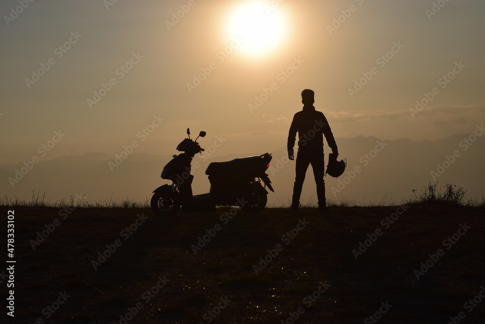 Fototapeta premium silhouette of a scooter and a man on a sunset