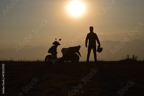 silhouette of a scooter and a man on a sunset