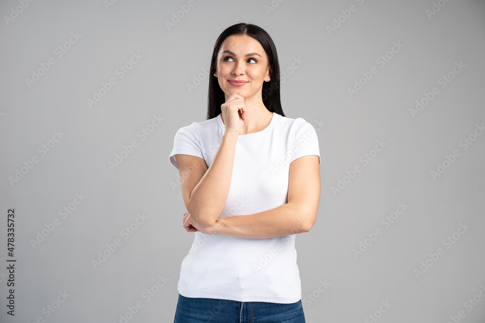Smart and thoughtful woman holding her chin and pondering idea, making difficult decision, looking uncertain doubtful. Indoor studio shot isolated on grey background Smart and thoughtful woman holding her chin and pondering idea, making difficult decision, looking uncertain doubtful. Indoor studio shot isolated on grey background