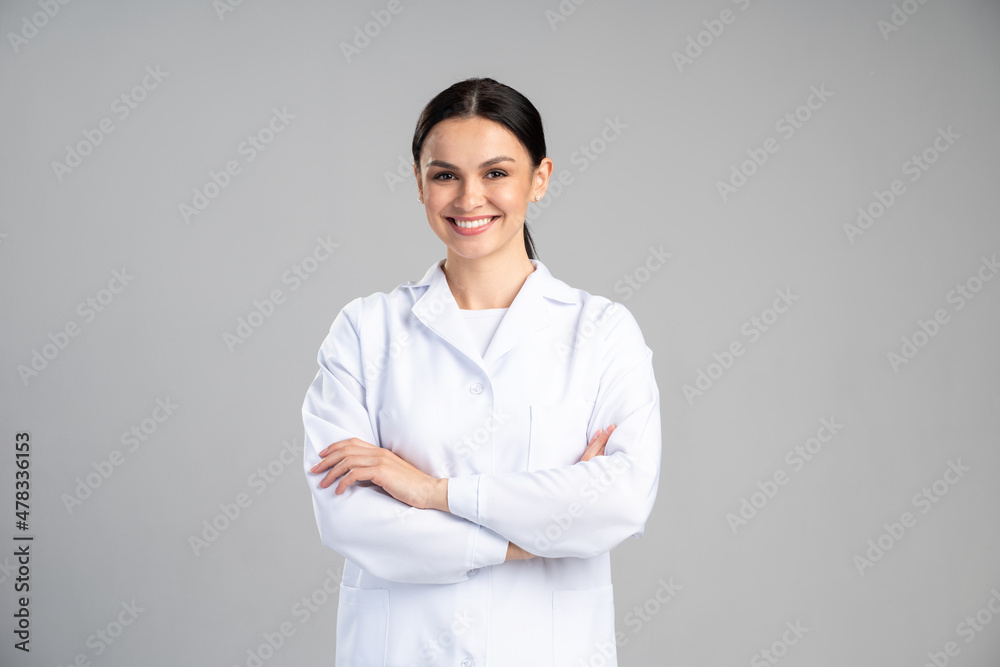 Photo of young happy woman professional wearing suit smiling friendly while posing arms crossed to the camera isolated on grey color background - obrazy, fototapety, plakaty 