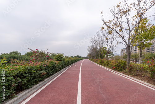 On a cloudy day, the red asphalt runway in the park © chen
