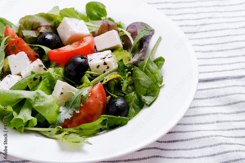 Fresh Greek salad in white plate. Space for text.
