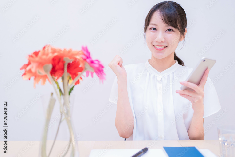 スマートフォンを持って喜ぶ女性