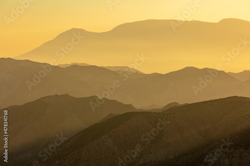 Sunrise in Andalusia: hazy mountains in the he desert of Hoya de Guadix, Spain © Chris