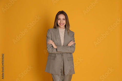 Portrait of beautiful young woman in fashionable suit on yellow background. Business attire © New Africa