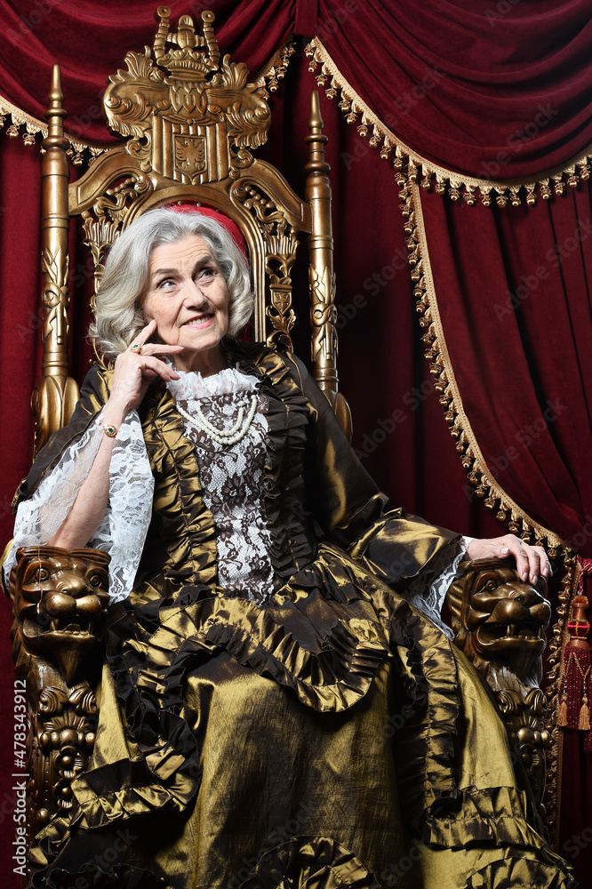 portrait of beautiful senior woman Queen posing on throne