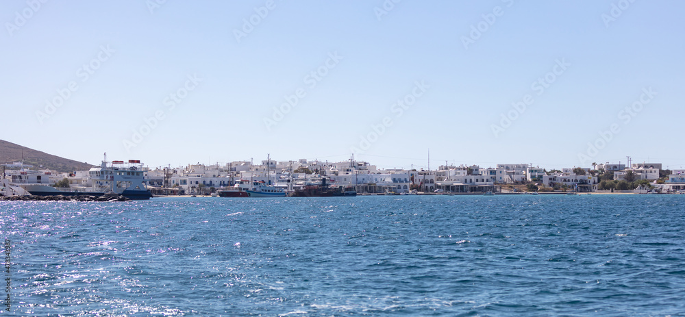 Antiparos island Cyclades Greece. Panoramic view of harbor buildings sea boats blue sky.