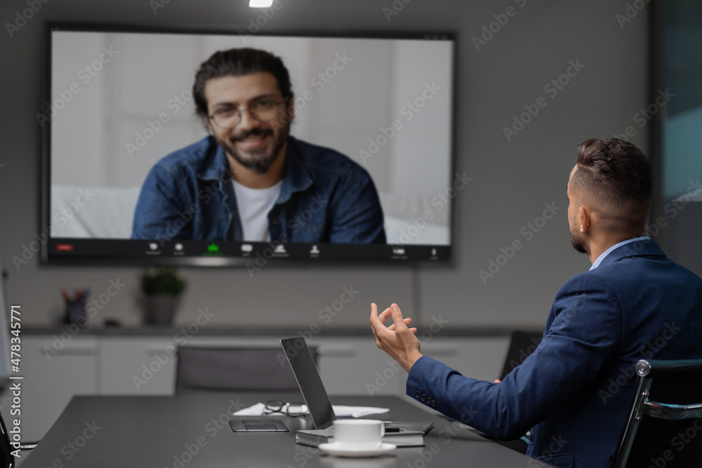 Obraz premium Middle eastern businessman having video chat with employee at office