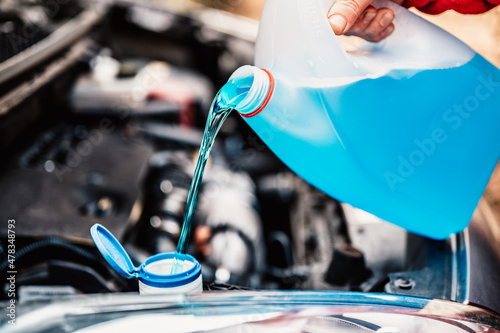 Pouring antifreeze. Filling a windshield washer tank with an antifreeze in winter cold weather. photo