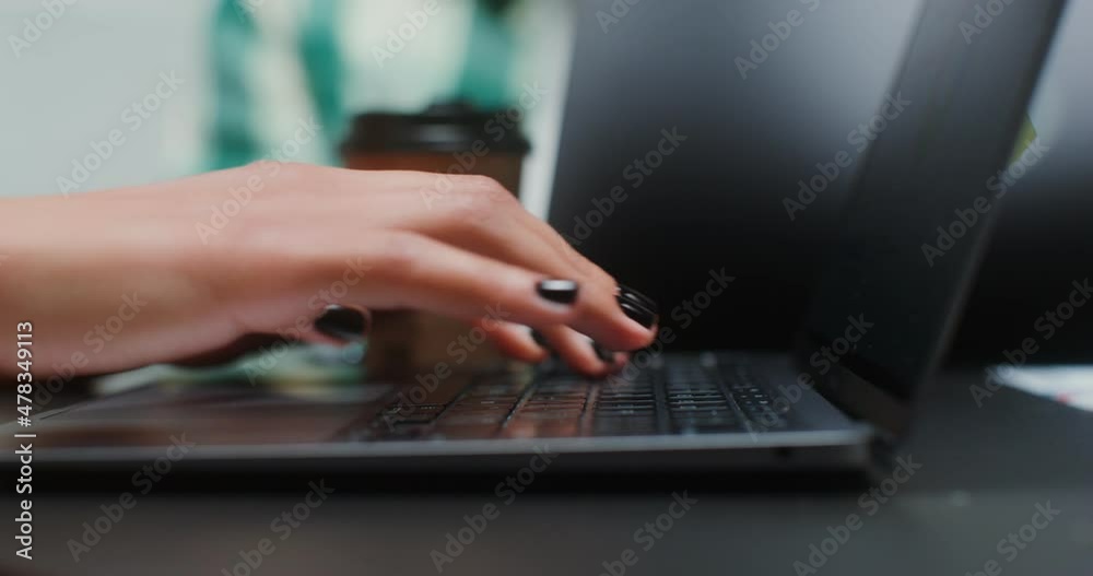 Close-up shot of woman's hand typing on laptop keyboard while sitting in office Close-up shot of woman's hand typing on laptop keyboard while sitting in office
