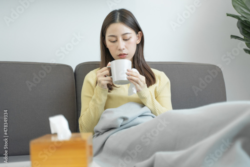 sick asian woman drinking a hot water