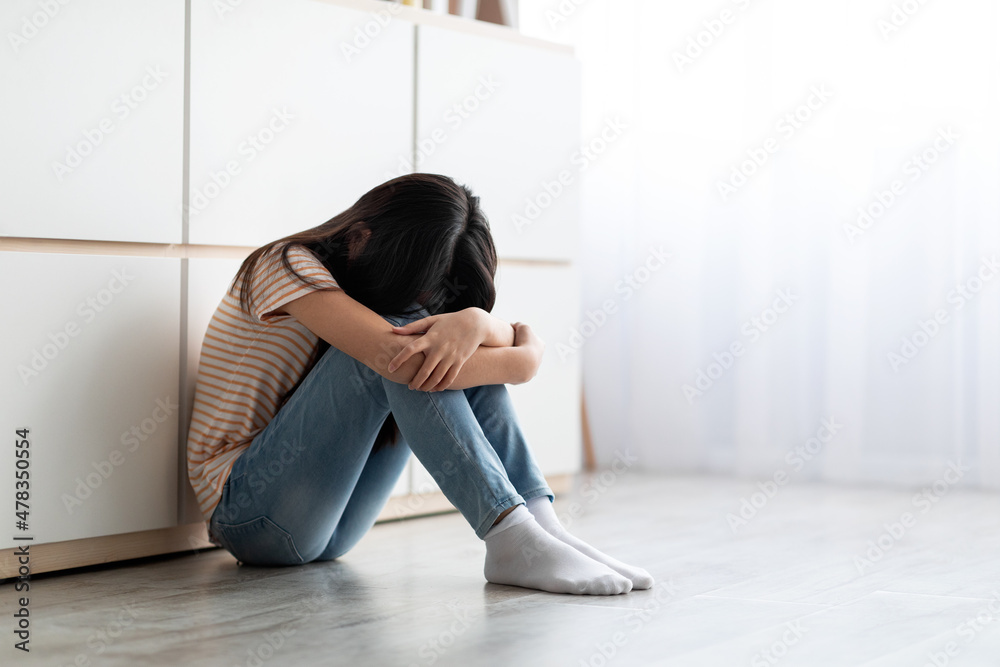 Upset long-haired brunette girl sitting on floor and crying Upset long-haired brunette girl sitting on floor and crying