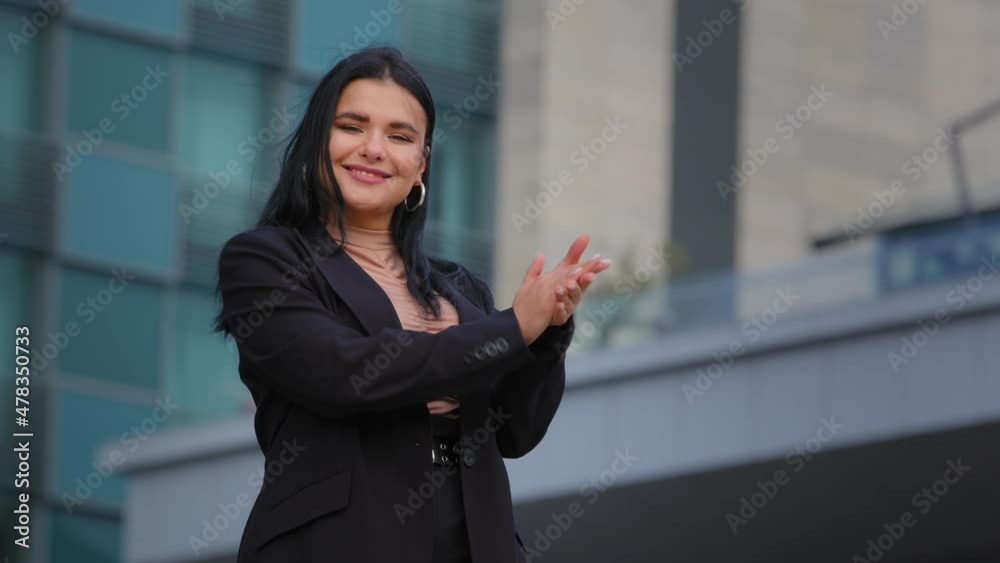 Enthusiastic young businesswoman standing on city building backround smiling clapping hands hispanic girl looking at camera applauding expresses approval admiration ovation greeting congratulations Enthusiastic young businesswoman standing on city building backround smiling clapping hands hispanic girl looking at camera applauding expresses approval admiration ovation greeting congratulations