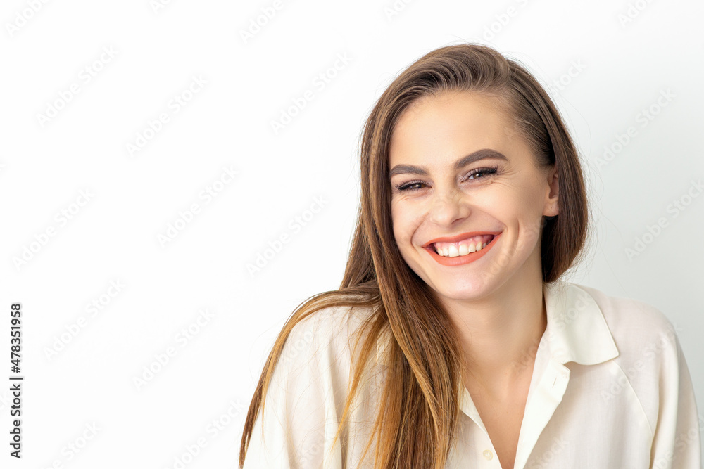 Beauty concept of woman. Portrait of a happy charming shy smiling young caucasian woman with long brown hair posing and looking at the camera over white background Beauty concept of woman. Portrait of a happy charming shy smiling young caucasian woman with long brown hair posing and looking at the camera over white background