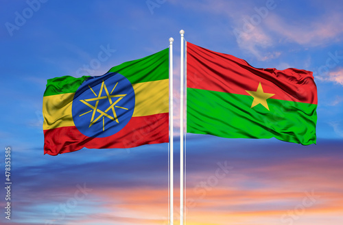 Ethiopia Burkina Faso two flags on flagpoles and blue cloudy sky