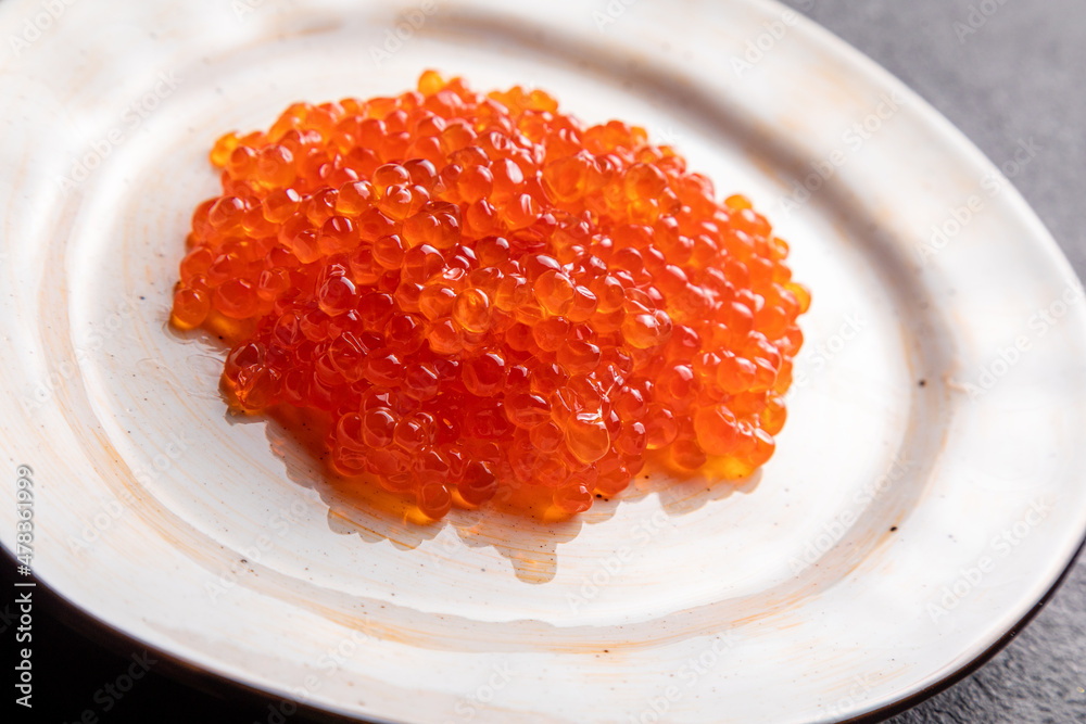 red caviar on a white plate, dark background, delicacy red caviar red caviar on a white plate, dark background, delicacy red caviar