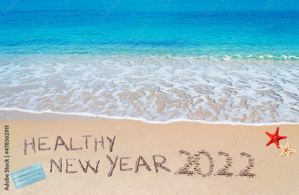 Naklejka premium healthy new year 2022 written on the sand