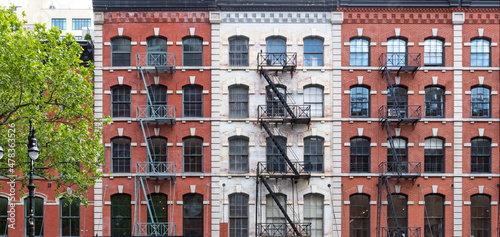 Block of old apartment buildings with windows and fire escapes in the Tribeca neighborhood of New York City