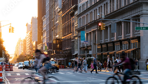 Crowded street scene with people, cars and bikes at the busy intersection of 23rd St and 5th Avenue in Manhattan New York City