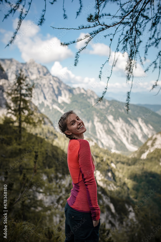 Happy woman enjoying her hike in Julian Alps in Slovenia on a beautiful sunny day on a late summer day.
