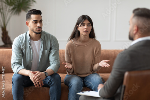 Couple talking at session with professional male therapist