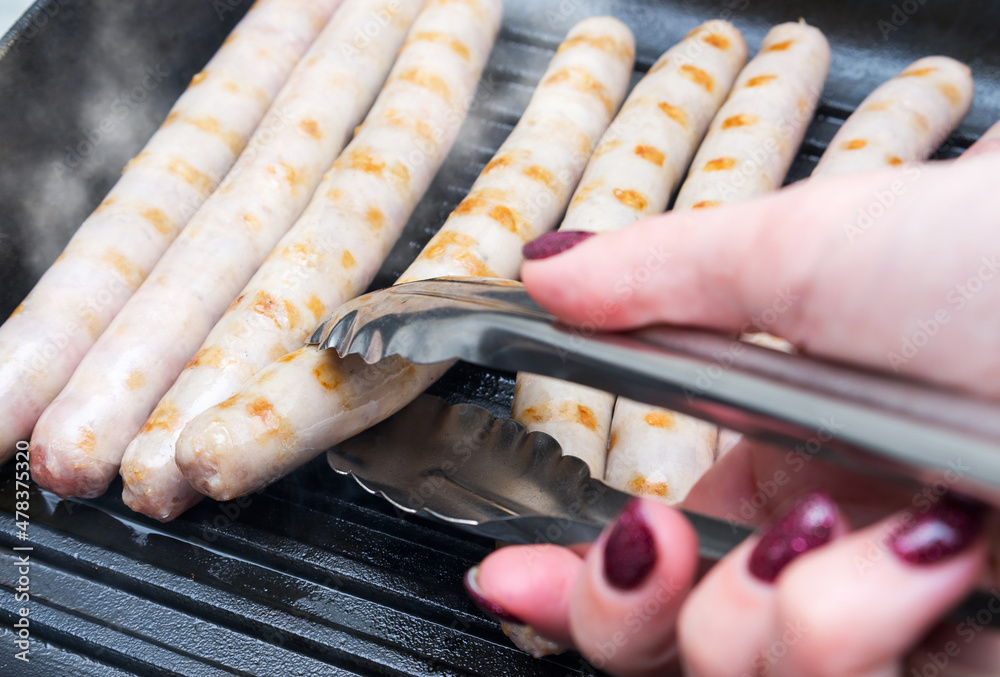 Pork sausages cooking in a griddle frying pan Pork sausages cooking in a griddle frying pan