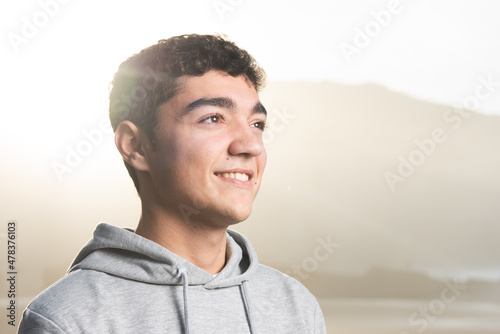 Portrait of smiling hispanic teenager boy at sunset