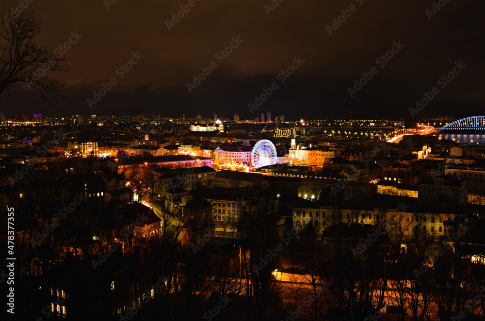 Aerial night light landscape of Square of Contracts (Contract Square) with Ferris wheel during Christmas holidays. Famous touristic place and romantic travel destination. Podil district, Kyiv, Ukraine