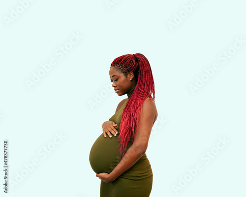 black pregnan woman wearing a green dress on a colorful background