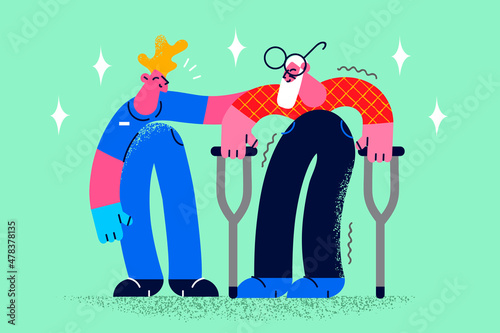 Caregiver help old man walking on crutches 