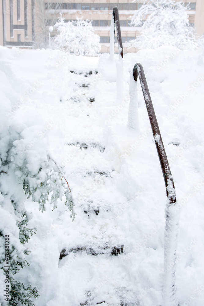 Street city steps are completely covered with snow. Snowfall in winter. The theme of problems of the municipal service of the city in winter.
