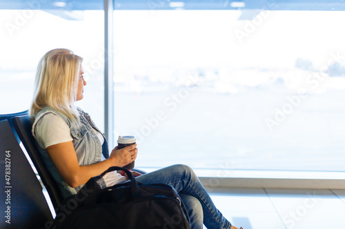 Young female passenger at the airport waiting for her flight