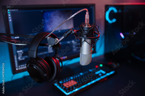 Professional microphone with headphones and podcasts equipment on the background