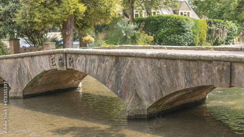 Old English stone bridge crossing a shallow river
