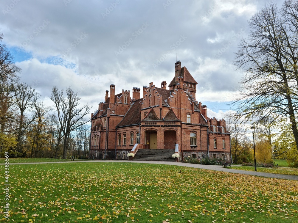 Beautiful old Latvian castle Jaunmoku among trees with yellowed leaves October 16, 2021