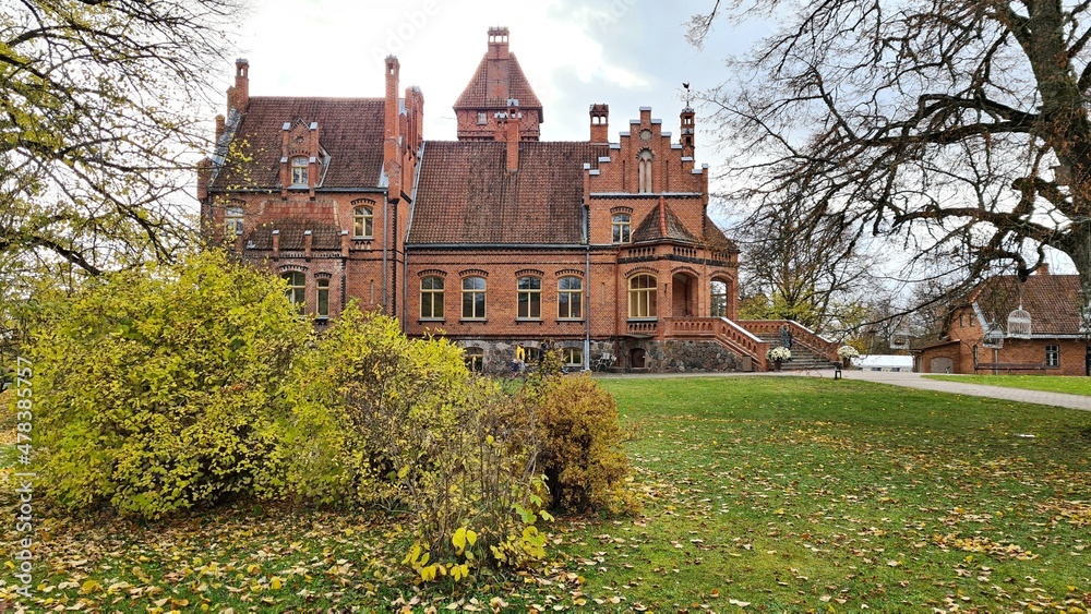 Beautiful old Latvian castle Jaunmoku among trees with yellowed leaves October 16, 2021