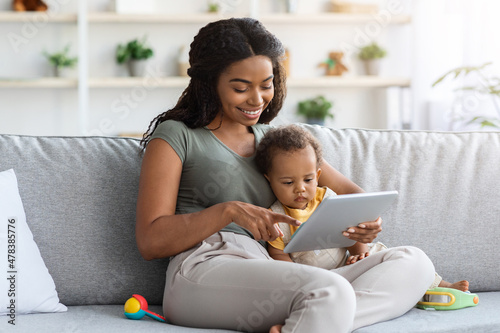 Babies And Gadgets. Happy Black Woman And Toddler Son Using Digital Tablet