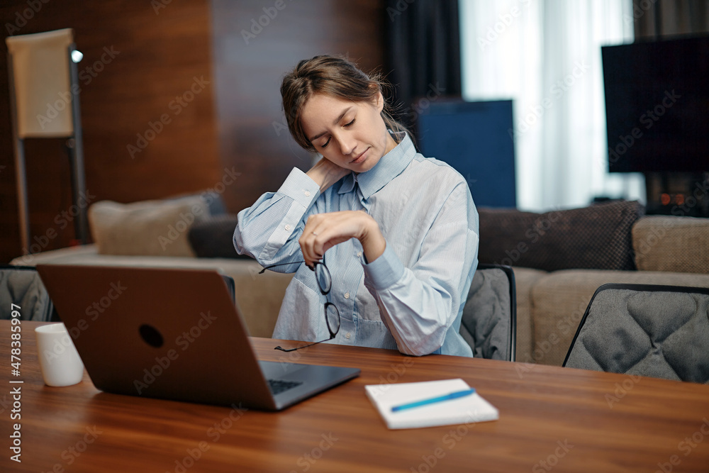 Neck Pain. Young tired woman massaging aching neck suffering cervical osteochondrosis ache from long working at laptop Neck Pain. Young tired woman massaging aching neck suffering cervical osteochondrosis ache from long working at laptop