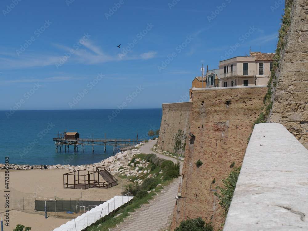 walkway of Trabucco, the ancient fishing machine in the sea, along the city walls the Swabian Castle in Termoli