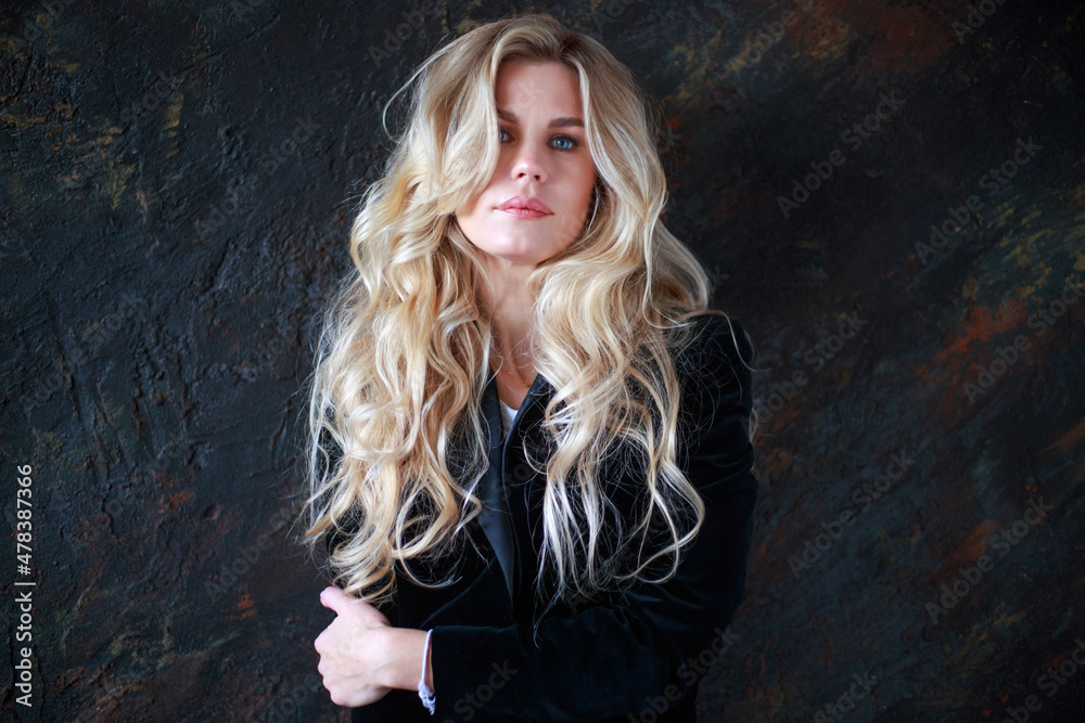 Fototapeta premium Lovely business lady in black suit, portrait woman with long blond curly hair