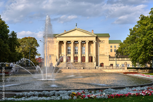 a fountain, flower beds and the facade of the historic opera house