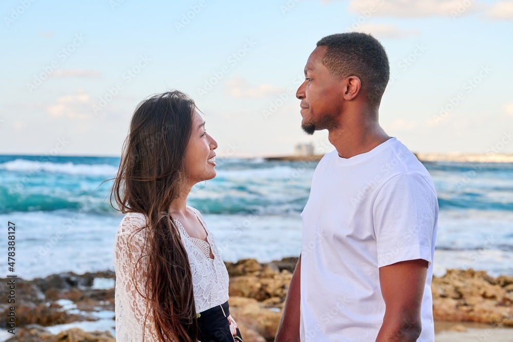 Young beautiful couple looking in the eyes in profile, on the seascape Young beautiful couple looking in the eyes in profile, on the seascape