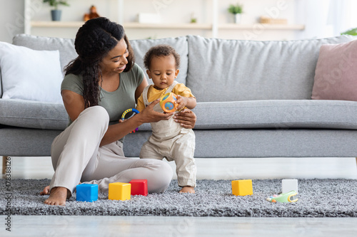 Fotografie, Obraz Caring Black Mom And Adorable Infant Son Playing With Toys At Home