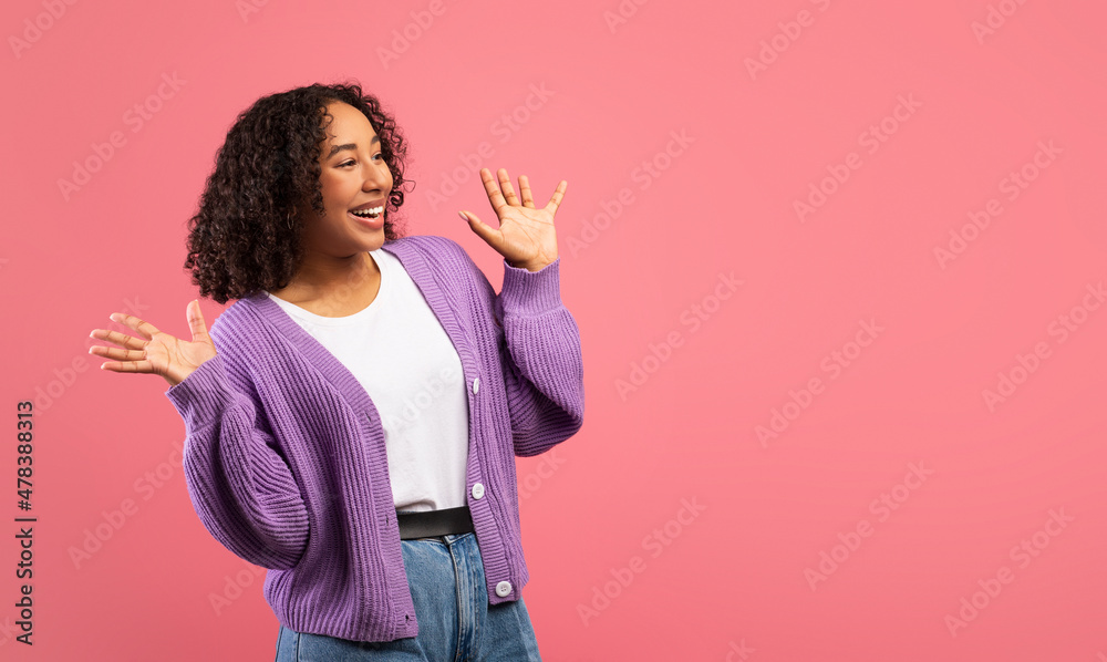 Emotional young black woman shouting in excitement, holding hands near face, looking at empty space over pink background Emotional young black woman shouting in excitement, holding hands near face, looking at empty space over pink background