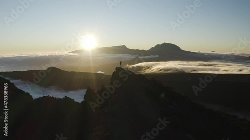 Aerial view of a person standing on the mountain top at sunset near Trou Fanfaron and Commerson Crater, Saint Joseph, Reunion. photo